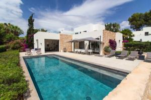 Villa con piscina frente a una casa en Villa Algarrobos, en Santa Eulària des Riu
