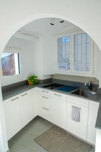 uma cozinha com armários brancos e um lavatório em Rustico al Sole - Just renewed 1bedroom home in Ronco sopra Ascona em Ronco sopra Ascona