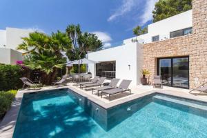 a swimming pool in the backyard of a house at Villa Higueras in Santa Eularia des Riu