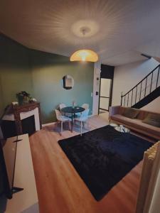 una sala de estar con una mesa y un sofá en Maison 8 couchages, en Le Mans