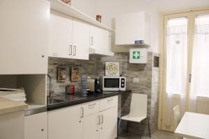 Una cocina con gabinetes blancos y un microondas. en Eufonia Vatican Days, en Roma