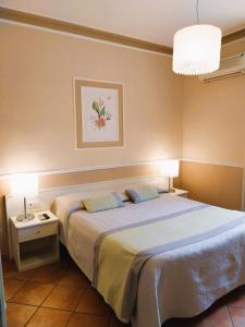 a bedroom with a large bed and two lamps at Hotel Ristorante Moderno in SantʼAntìoco