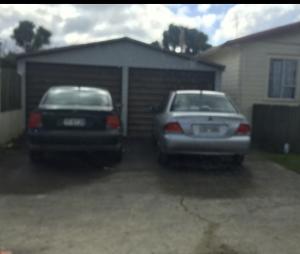 two cars parked in front of a garage at Rotorua Holiday Villa in Rotorua