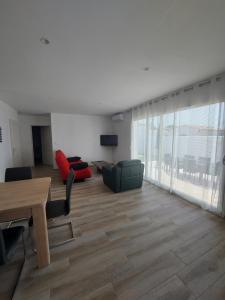 a living room with a couch and a table and chairs at A bâbord : maison chaleureuse à 300m de la plage in La Cotinière