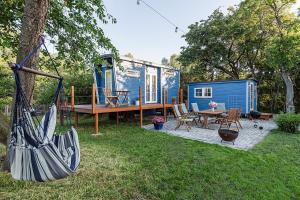 una casita azul en un patio con un columpio en Tinyhouse am Obsthain, en Poseritz