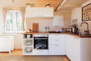 uma cozinha com armários brancos e um lavatório em Tinyhouse am Obsthain em Poseritz