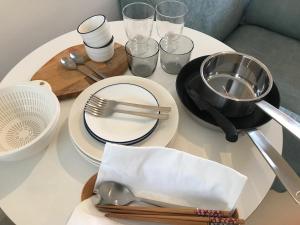 een witte tafel met borden en keukengerei erop bij Oku-Shibu Residence in Tokyo