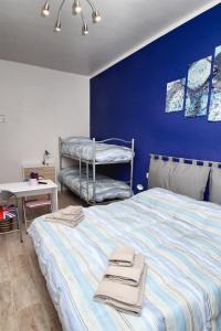 1 dormitorio con 1 cama grande y pared azul en B&B Il Rosso e il Blu, en Cuneo