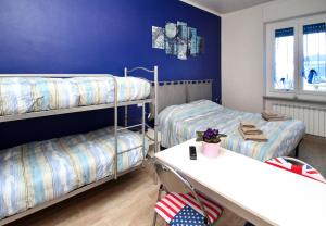 クーネオにあるB&B Il Rosso e il Bluの二段ベッド2台とテーブルが備わる客室です。