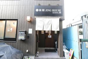een gebouw met een bord dat leest zijn woonhuis bij 無料wi-fi JING HOUSE 秋葉原 電動自転車レンタル in Tokyo