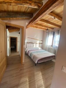 um quarto com uma cama e tectos em madeira em Casa Juan em Gea de Albarracín