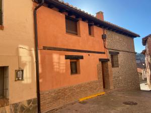 un edificio arancione con una porta sul lato di Casa Juan a Gea de Albarracín