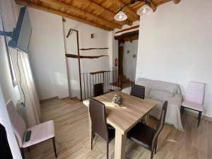 uma sala de jantar com uma mesa e um sofá em Casa Juan em Gea de Albarracín