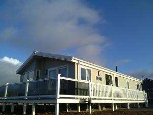 uma casa móvel com um alpendre e uma varanda em Turnberry lodge em Girvan