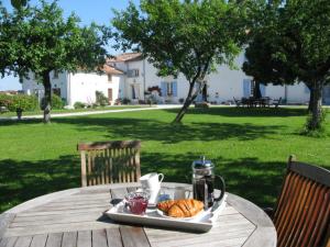 una bandeja de cruasanes y café en una mesa de picnic en La Belle Parenthèse, en Vergné
