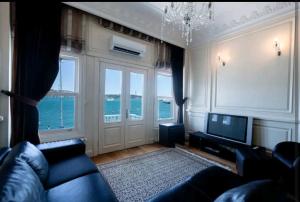uma sala de estar com um sofá e uma televisão em İstanbul Bebek Yalı em Istambul