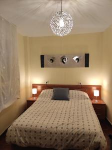 ein Schlafzimmer mit einem Bett mit zwei Leuchten in der Unterkunft Cuenca 3 in Gijón