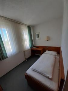 a bedroom with a bed and a desk and window at Edit Pension Rossau in Rossau