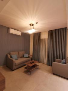 uma sala de estar com dois sofás e uma mesa em Dara apartment hotel em Umm Uthainah