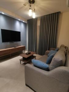 a living room with a couch and a flat screen tv at Dara apartment hotel in Umm Uthainah