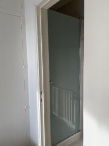 een glazen deur in een kamer met een spiegel bij Zeedijk appartement Nieuwpoort in Nieuwpoort
