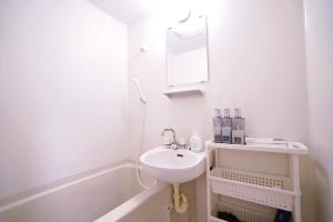 a white bathroom with a sink and a bath tub at TOKYO ICHIBAN ASAKUSA in Tokyo
