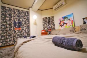 東京的住宿－TOKYO ICHIBAN ASAKUSA，酒店客房,配有一张床铺,上面有一条紫色毛巾