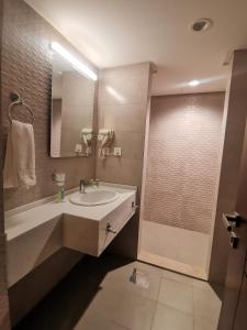 uma casa de banho com um lavatório e um chuveiro em Dara apartment hotel em Umm Uthainah