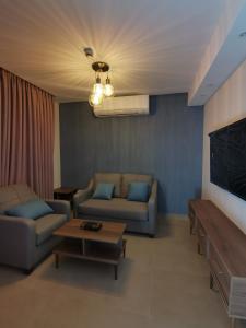 a living room with two couches and a table at Dara apartment hotel in Umm Uthainah