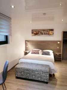um quarto com uma cama grande e uma cadeira em KEBESPRE em Lapoutroie
