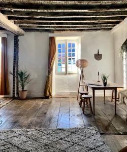 sala de estar con mesa y ventana en Abury, tables et chambres , randos et bien être à la montagne, en Barcus