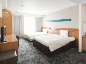 a hotel room with two beds and a television at Vessel Hotel Ishigakijima in Ishigaki Island