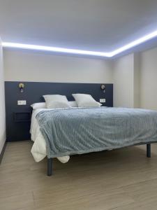 a bedroom with a large bed with a blue headboard at Loft 3 Ramon y Cajal Maracena in Maracena