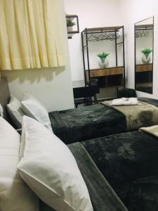 Habitación con 2 camas y 2 espejos. en Hotel Malka, en São Paulo