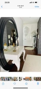 uma sala de estar com uma mesa branca e um espelho em Pé na Areia na Póvoa do Varzim
