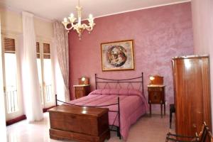 - une chambre rose avec un lit et un lustre dans l'établissement Art Of Living - Esclusivo 130 MQ, à Isernia
