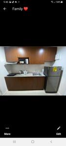 a small kitchen with a sink and a refrigerator at VICTORIA DE MAKATI Two (2) Bedroom Up and Down Condo in Manila