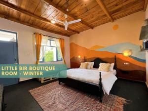 a bedroom with a bed with a painting on the wall at Little Bir in Bīr