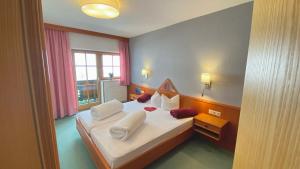 A bed or beds in a room at Pension Alpin