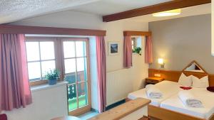 A bed or beds in a room at Pension Alpin