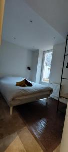 une chambre avec un lit dans une pièce avec une fenêtre dans l'établissement APPARTEMENT LES MOUETTES, à Saint-Valery-en-Caux