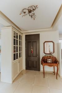 a hallway with a door and a table and a mirror at Villa Αρμονία στη φύση in Áno Kalésia