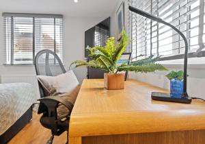 a desk with plants on top of it with a lamp at St Helens Studio with Free Parking by My Getaways in Hove
