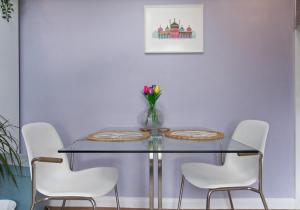 a dining room table with white chairs and a vase of flowers at St Helens Studio with Free Parking by My Getaways in Hove