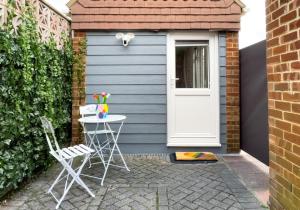 a small blue shed with a table and chairs in front of it at St Helens Studio with Free Parking by My Getaways in Hove