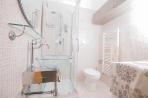 y baño con lavabo de cristal y aseo. en Suite Gaia, en Bari
