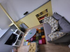 a living room with a couch and a surfboard on a rug at TI CAZ PYRENEES (Chambre d'Hôtes) in Mirepeix