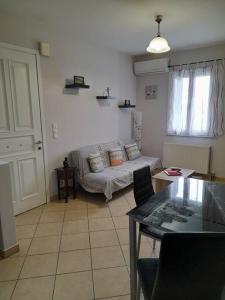 ein Wohnzimmer mit einem Sofa und einem Tisch in der Unterkunft SummerAndros Windmill in Ándros