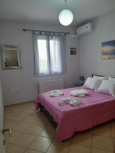 una camera con letto rosa e finestra di SummerAndros Windmill ad Andro