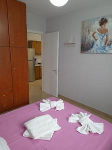 Una cama morada con toallas encima. en SummerAndros Windmill, en Ándros